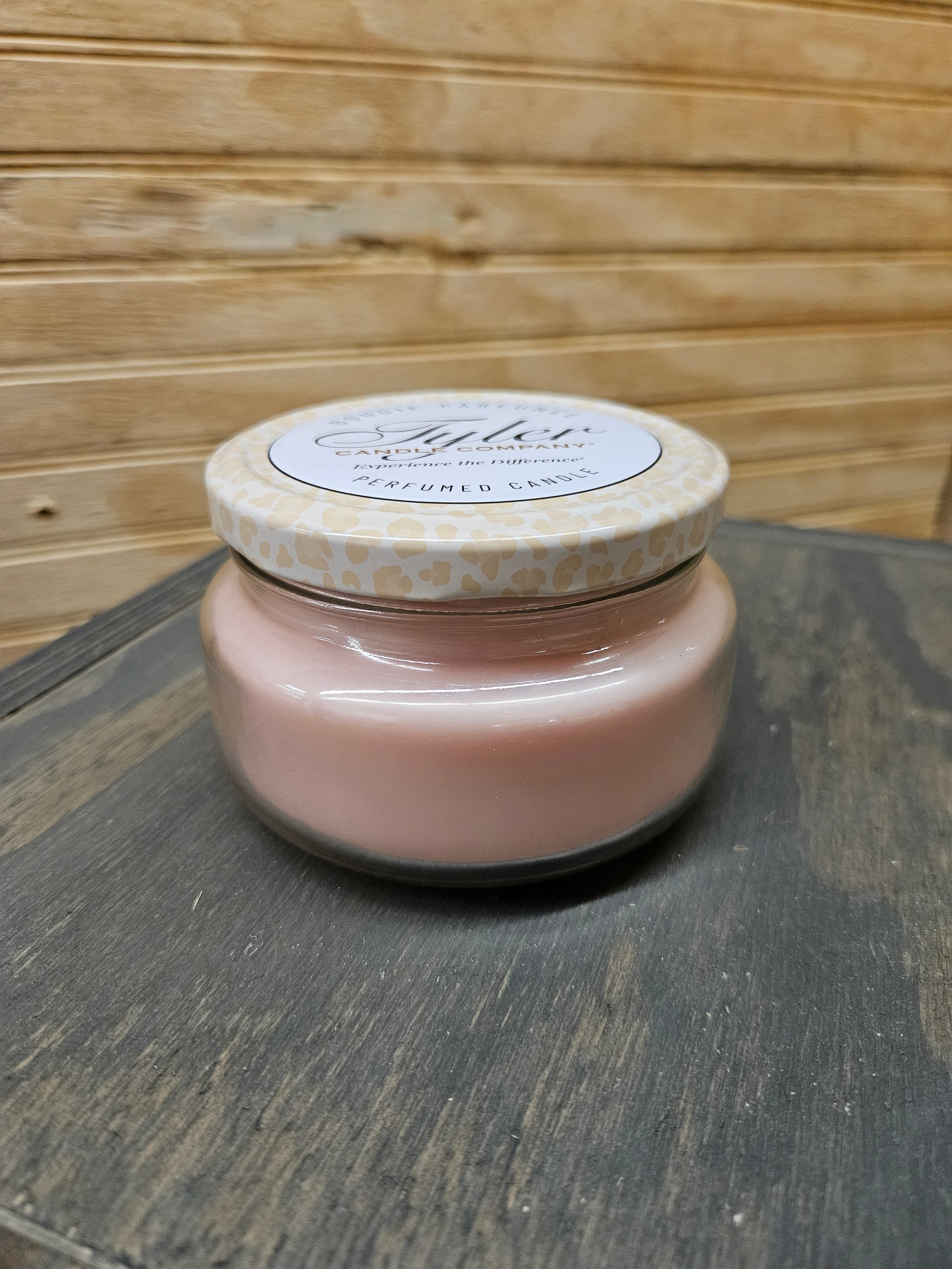 11oz Two Wick Tyler Candle in Bless Your Heart scent, pink jar with leopard-pattern lid on wood surface.